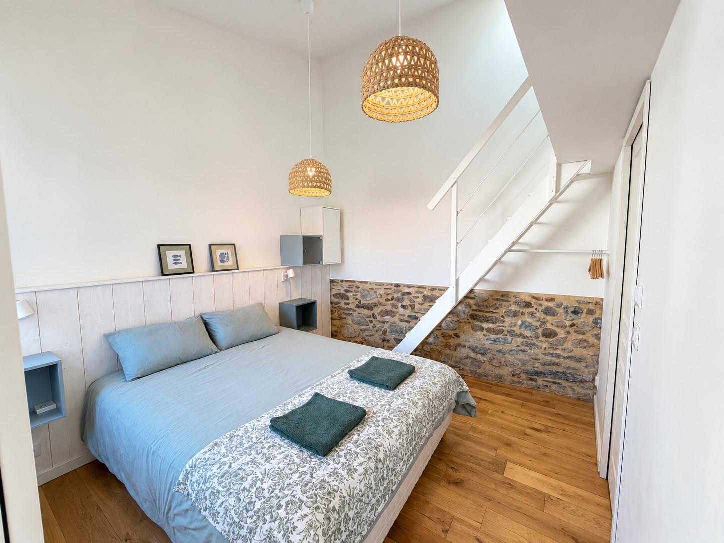 La chambre de la dépendance, soubassement en pierre et escalier de la mezzanine