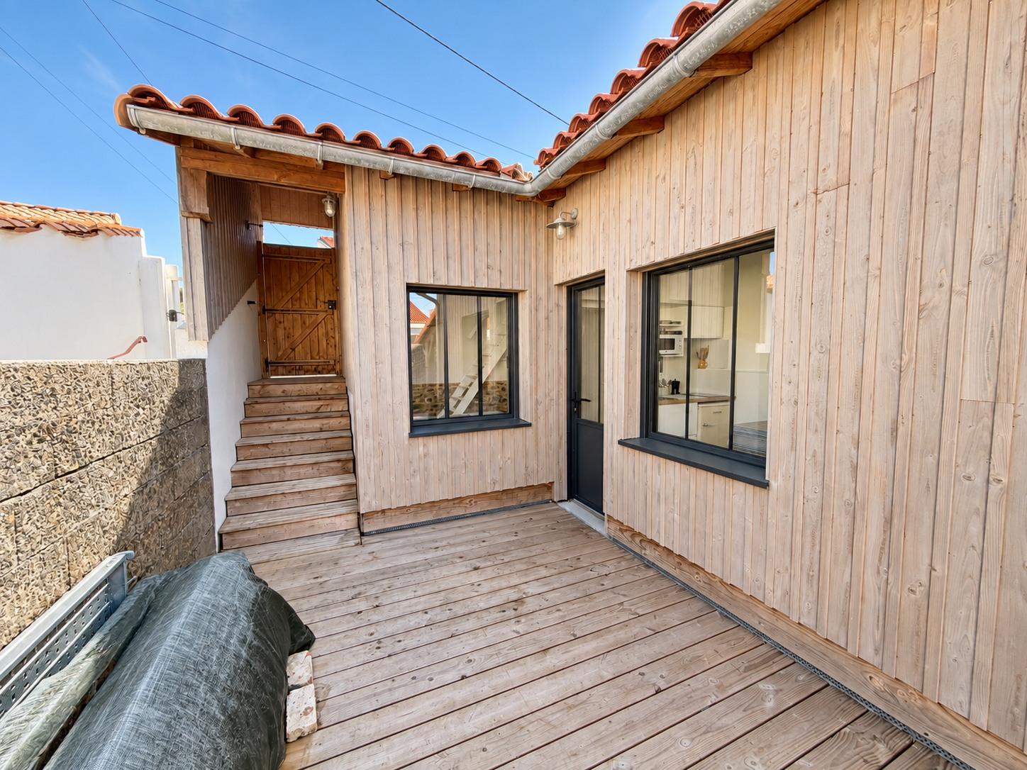 La dépendance et son bardage en bois clair, depuis la terrasse