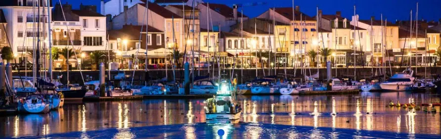 Le port à la nuit tombée, les bateaux devant les façades illuminées